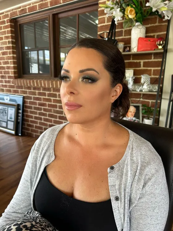 Olive-green smoky eye with a defined brow and a terracotta-pink lip