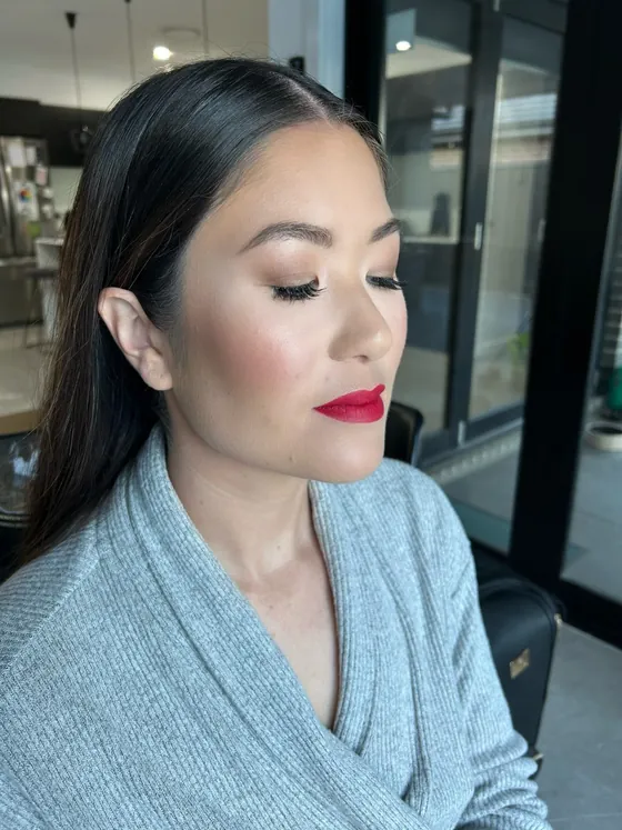 Classic red matte lip with soft taupe eyeshadow, fluttery lashes and luminous skin