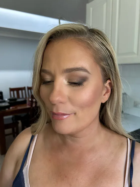 Taupe smoky eye with glowing skin and a glossy rose lip